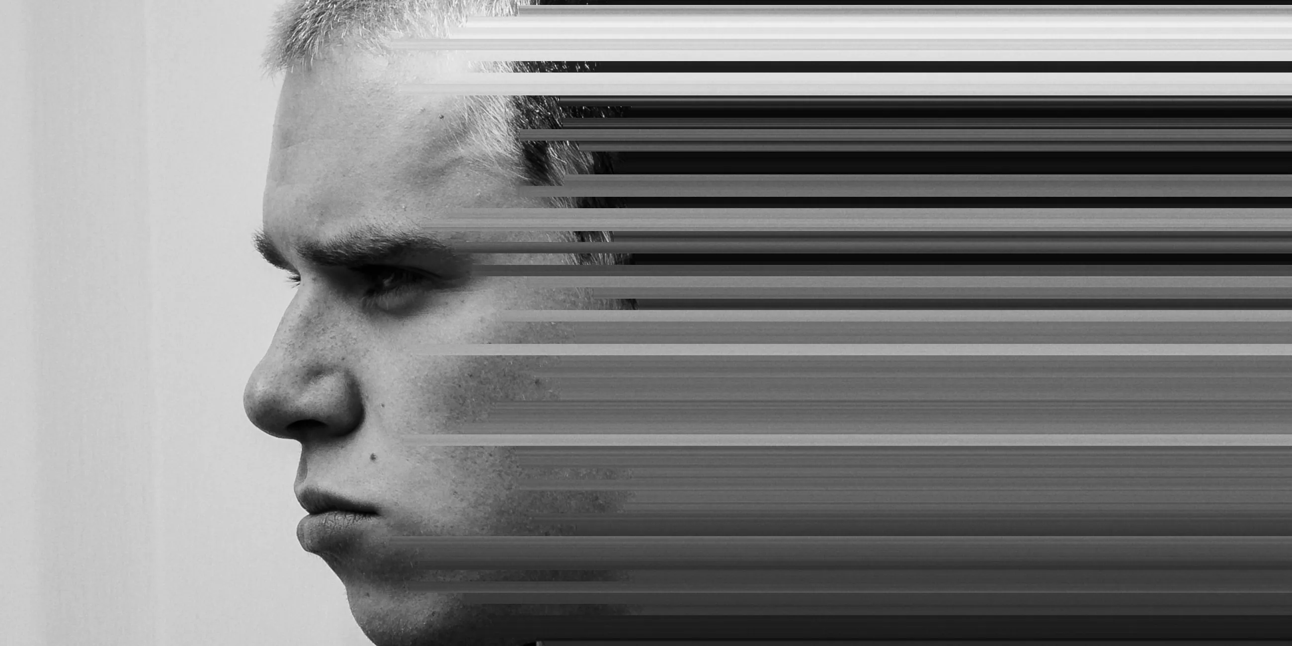 A man in profile in black and white, rows of pixels stretched out sideways from his eye